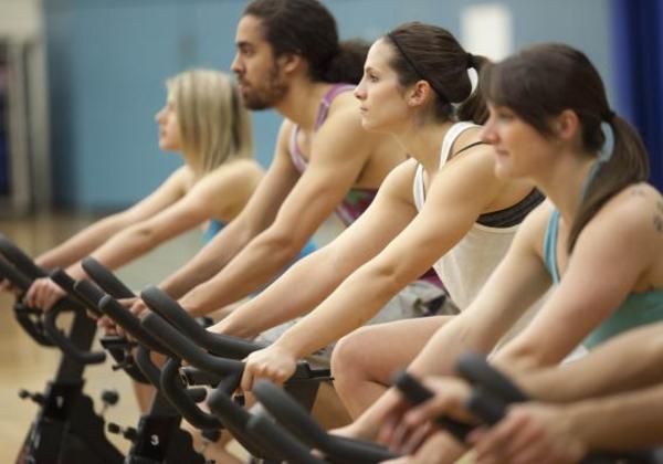 One male and three females on exercise bikes
