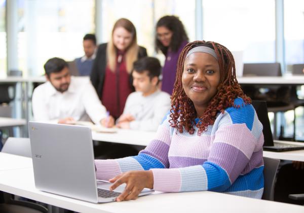 Graduate students working together in a classroom. 