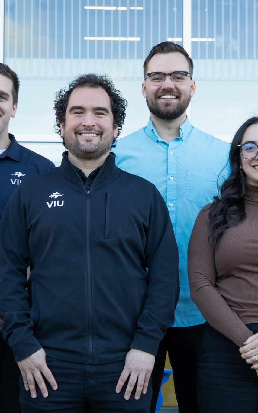 Smiling people standing together outside a building